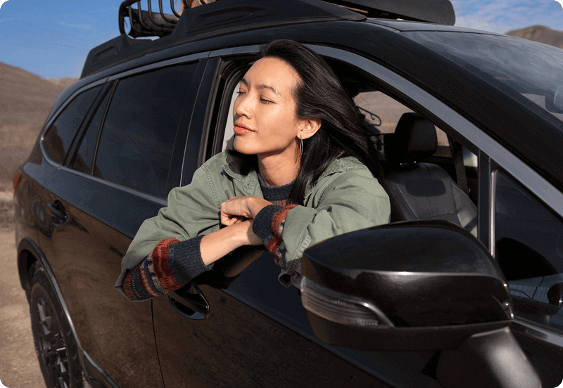 Person taking in the air out of the window of her car. 