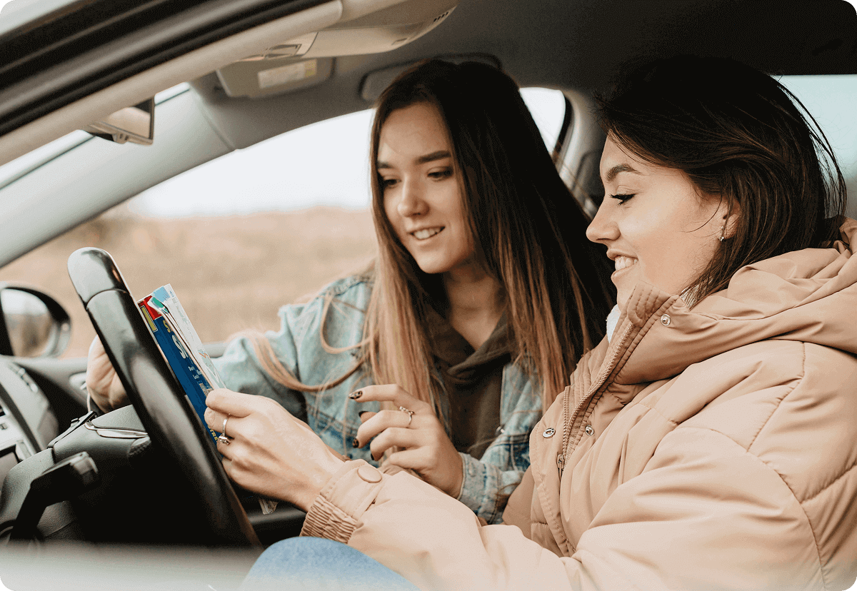 Two friends in a car, looking for directions.