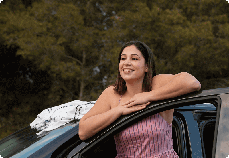 Woman hanging outside her car. 