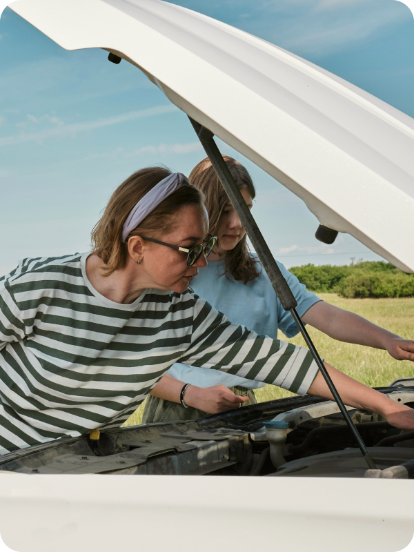 A woman attending a broken car.