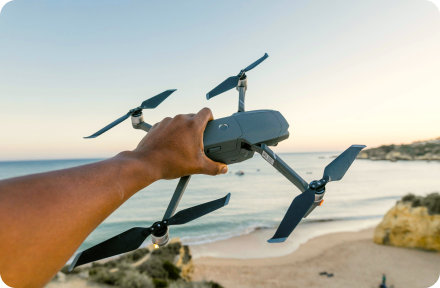 A man holding a drone during his vacation on a seaside