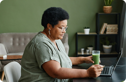 Retiree sitting in from of her laptop at home in France.