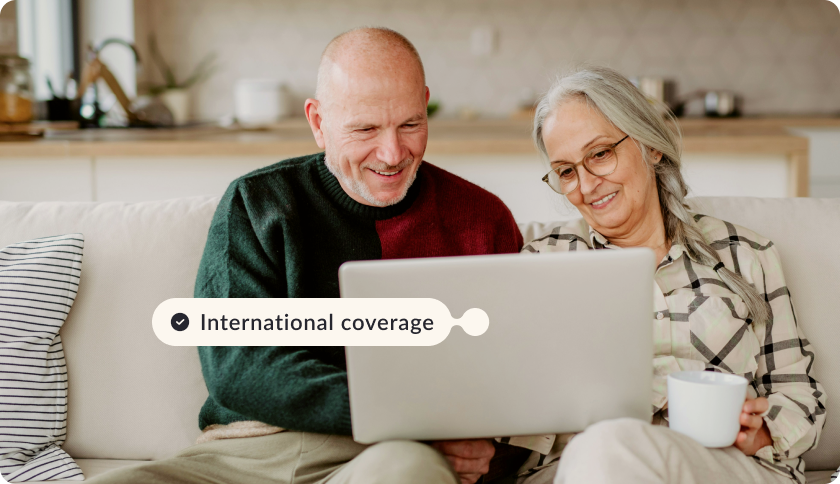 An older couple checking their health insurance coverage in Portugal on a laptop.