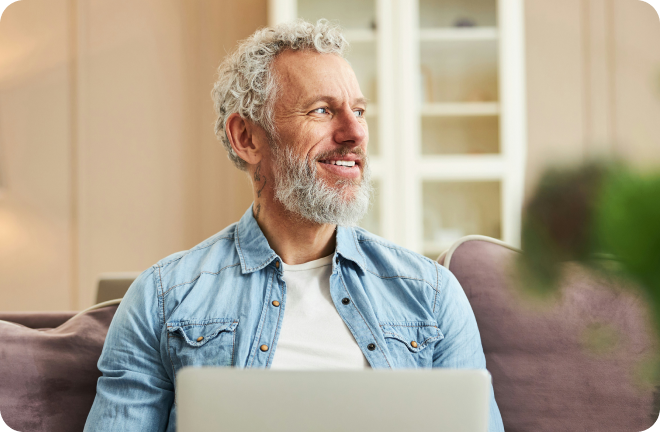 Retiree at home on laptop in Greece
