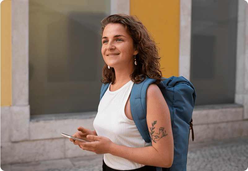 Woman walking through streets in Spain checking her golden visa application status on her phone