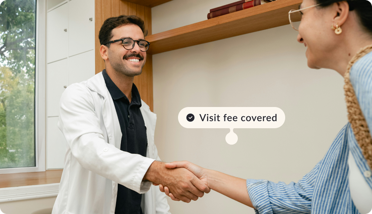 Doctor shaking a patient hand with a tag visit fee covered
