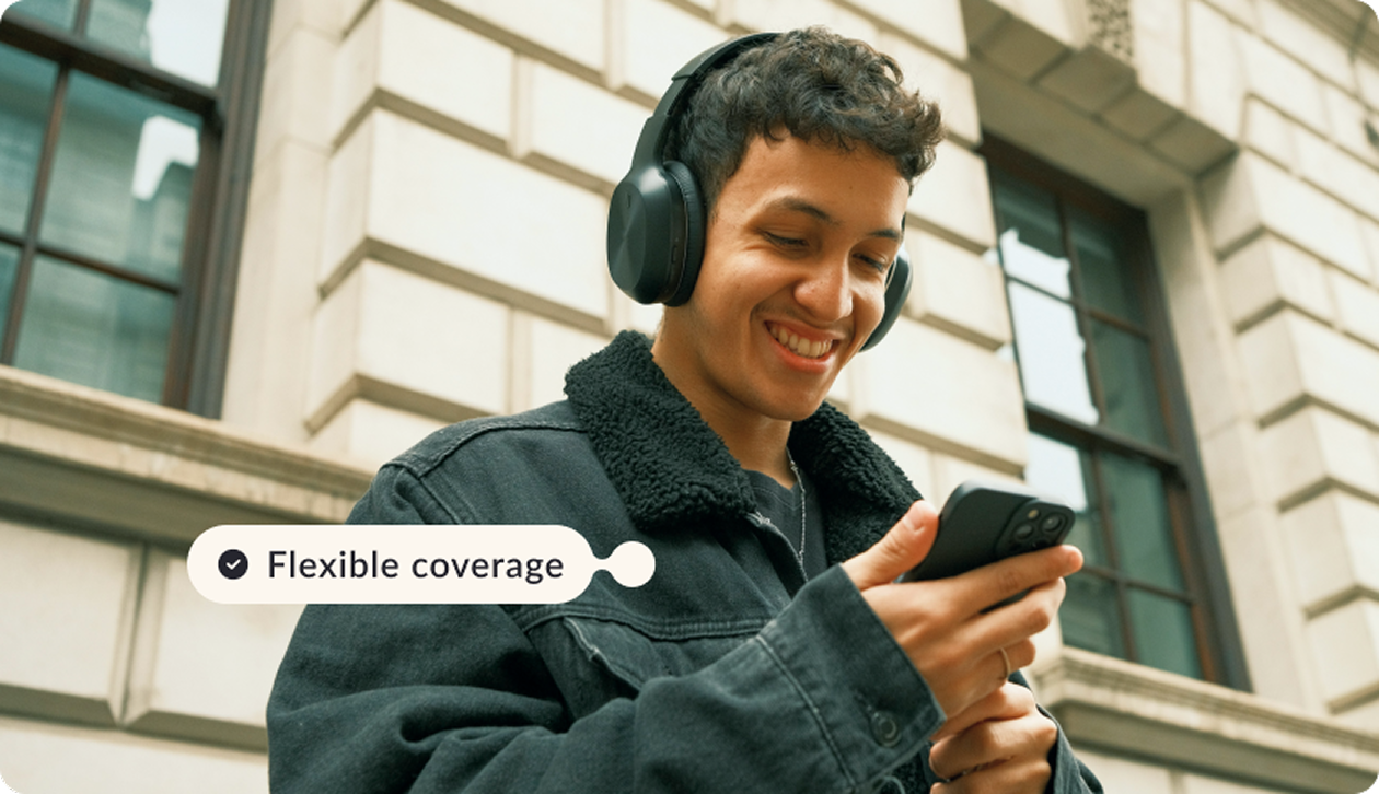 a young men smiling while looking at his phone