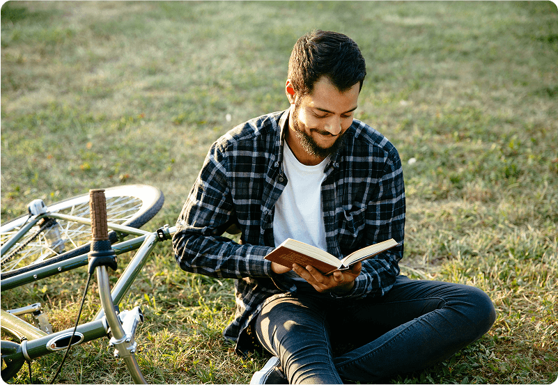 Student reading a book in the park. 