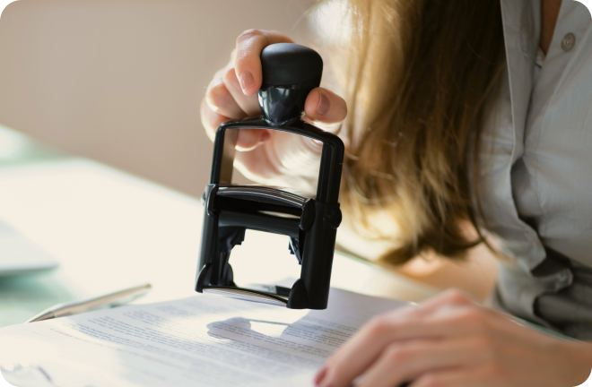 A visa stamp being put on a document.