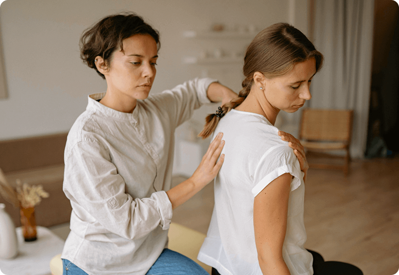 Woman exercising at a physiotherapist office, assisted by a specialist. 