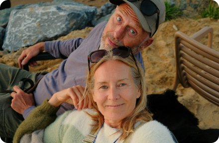 Older couple laying on a beach.